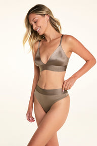 On a white studio backdrop, Meagan wears the Stretch Satin Triangle Bralette and Stretch Satin Highwaist Thong in Sable. The bralette features a deep V-neck, adjustable straps, and a wide wireless band, while the high-waisted thong has a wide waistband.