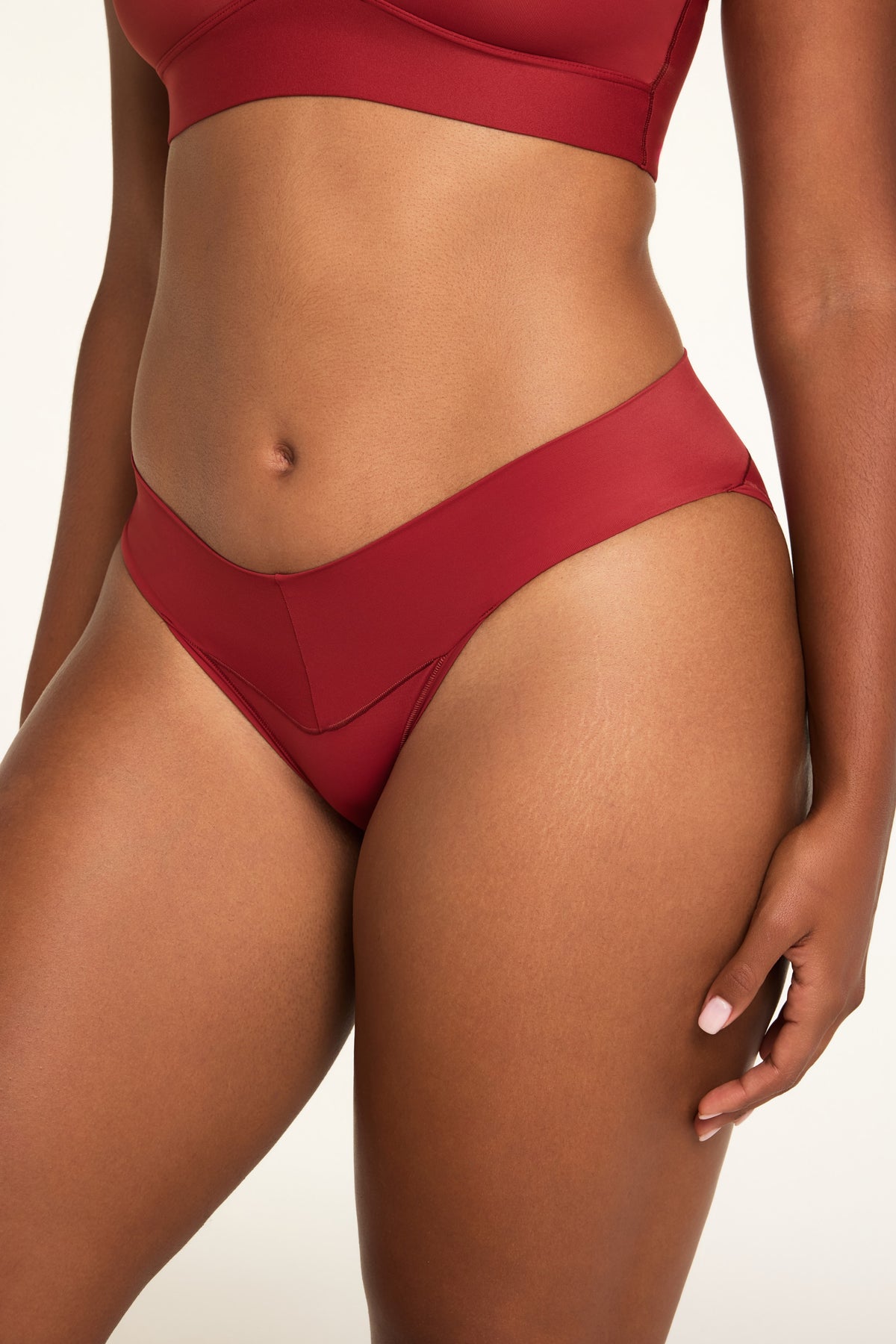 Side on-model view of the Bliss Low Rise Bikini in Ruby paired with the BlissSmooth Bralette in Ruby.