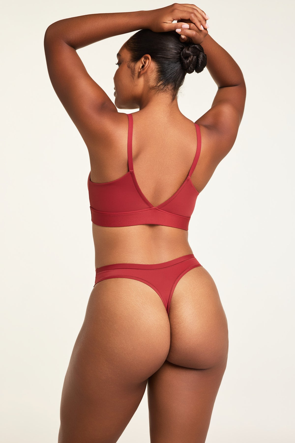 Side on-model view of the Bliss Thong in Ruby paired with the Bliss Triangle Bralette in Ruby.
