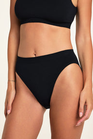 Side on-model view of the Knit Seamless French Cut Brief in Black paired with the Knit Seamless Bralette in Black.