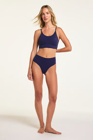 On a studio backdrop, Holly wears the WhippedKnit Scoop and No-Show Highwaist Thong in Noir, shown full length from the front.