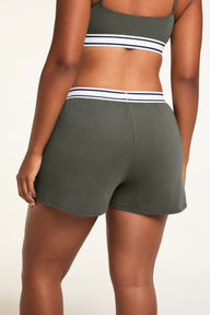 Three-quarter back view of the Cloud Cotton Short in Olive paired with the Cloud Cotton Bandeau Bralette in Olive.