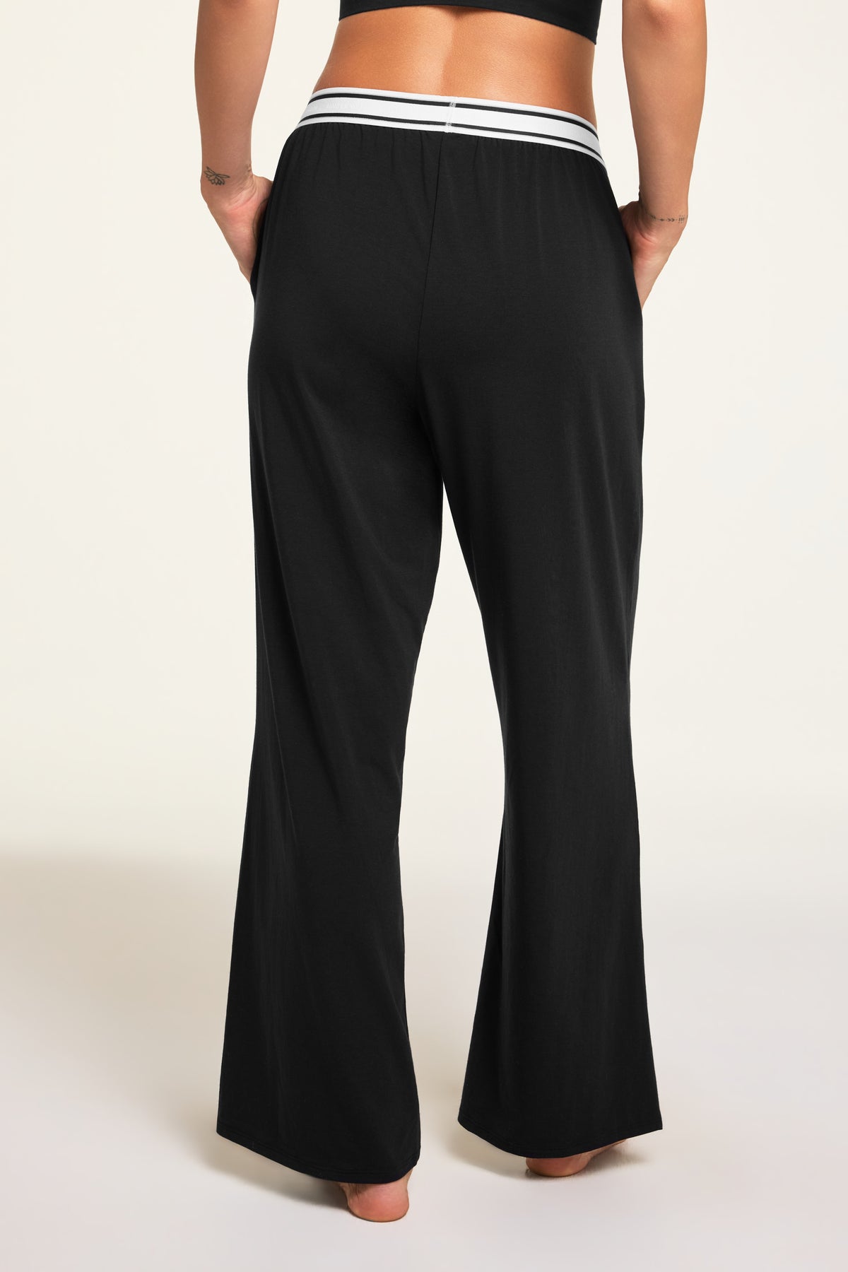 Three-quarter back view of the Cloud Cotton Pant in Black paired with the Cloud Cotton Long Sleeve T-Shirt in Black.
