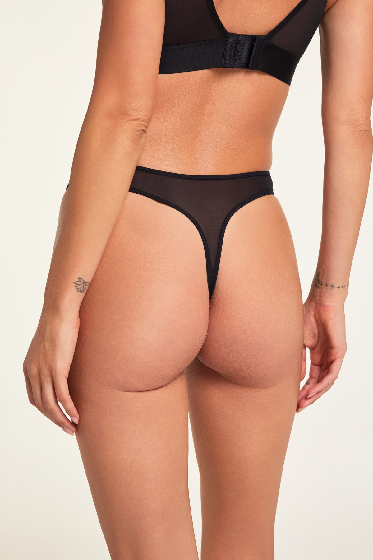 Three-quarter back view of the ComfortMesh™ Thong in Black paired with the ComfortMesh™ Triangle Bralette in Black.