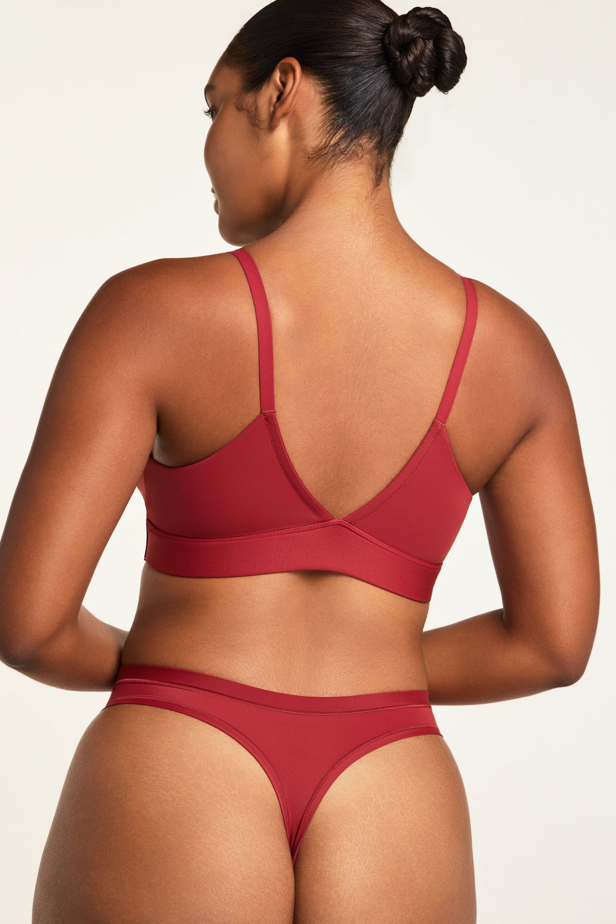 Three-quarter back view of the Bliss Triangle Bralette in Ruby paired with the Bliss Thong in Ruby.