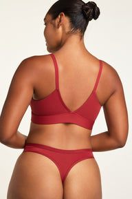 Three-quarter back view of the Bliss Triangle Bralette in Ruby paired with the Bliss Thong in Ruby.