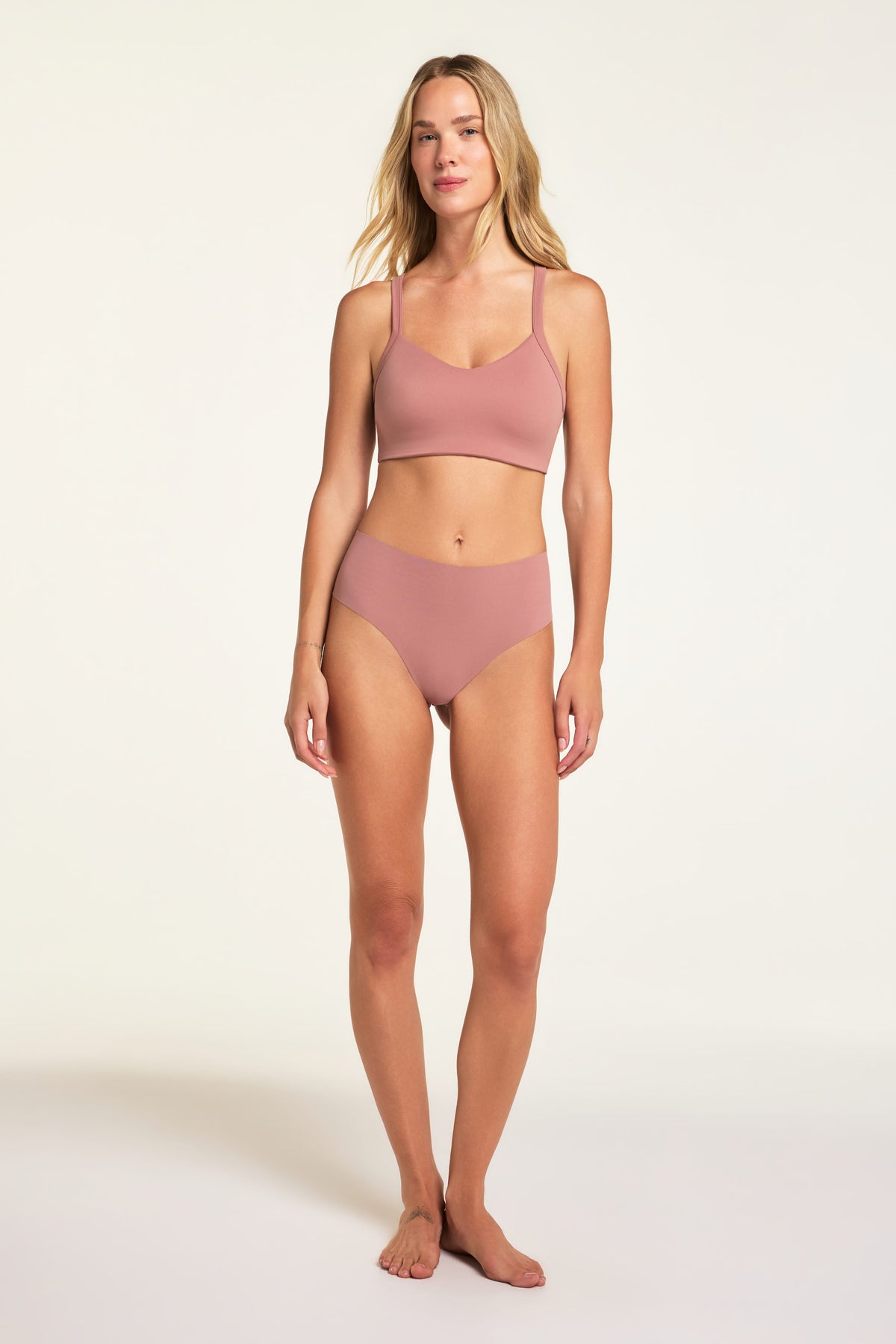 On a light studio backdrop, Holly wears the Whipped Knit V-Neck and No-Show Highwaist Thong in Plum, shown from head to toe.