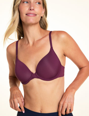 On a light studio backdrop, Meagan wears the Base T-Shirt Bra in Eggplant. The close-up image highlights the smooth molded cups, underwire support, adjustable straps, and deep V-neckline. sizing: Meagan wears size 34B