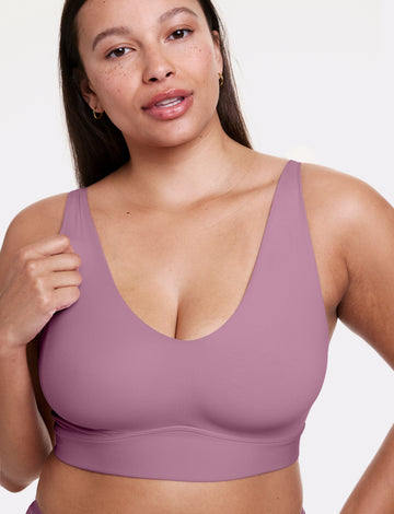 In a studio setting, Alana wears the Bliss Bralette in Mirage, shown in a close-up front view with a scoop neckline, wireless cups, and a smooth, wide underband. The soft fabric provides lightweight, comfortable support. sizing: Alana wears size Large