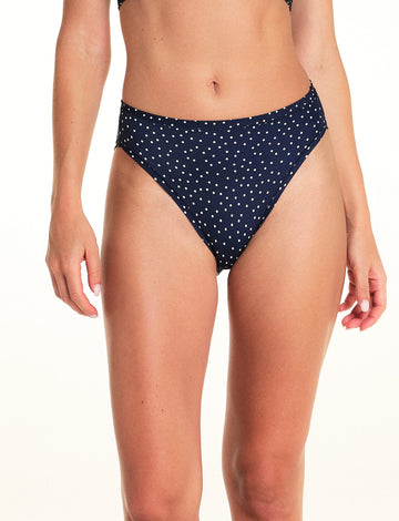 On a light studio backdrop, Alexis wears the Bliss French Cut in Navy Dot. The close-up image highlights the high-cut leg openings, mid-rise waist, and allover white dot print. sizing: Alexis wears size Small