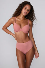 On a light gray studio backdrop, Courtney wears the Bliss Highwaist Brief in Cinnamon with a matching bra. A full-body front view highlights the smooth fabric, high-rise waist, and full-coverage silhouette. sizing: Courtney wears size Small