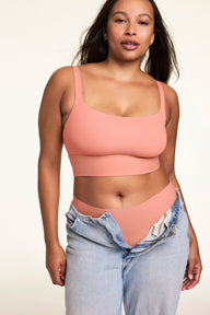 Against a neutral studio backdrop, Alana wears the Bliss Squareneck Bralette in Cabana with matching underwear and low-rise jeans, showcasing the square neckline, wide comfort band, and smooth fit.  sizing: Alana wears size Large