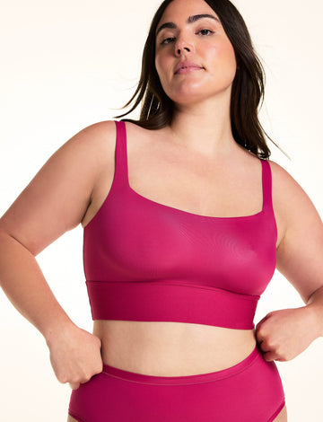 On a light studio backdrop, Alessandra wears the Bliss Square Neck Bralette in Winterberry. The front view highlights the square neckline, wide comfort band, smooth fabric, and supportive straps. sizing: Alessandra wears size Large