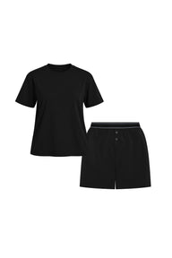 Flat lay of the Cloud Cotton Sleep Set in Black, featuring a short-sleeve tee with chest pocket and matching boxer-style sleep shorts. The shorts have a button fly and tonal waistband with a thin black stripe detail. Displayed against a white background for a clean, minimal presentation.