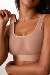 On a light studio backdrop, Ally wears the ComfortMesh™ Scoop Bralette in Taupe. A close-up view highlights the scoop neckline, sheer mesh fabric, wide comfort band, and double shoulder straps. sizing: Ally wears size Small