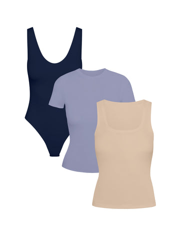 Product shot of Harper Wilde The Bliss Layers Trio — Navy Bliss Plunge Bodysuit, Periwinkle Bliss Tee, and Beige Bliss Tank, three everyday Bliss essentials to mix, match, and layer for fall