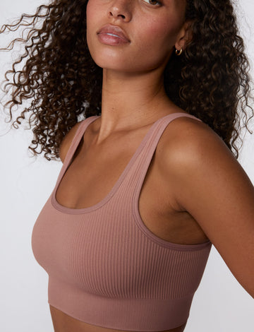 In a studio setting, Courtney wears the Ribbed Seamless Scoop Bralette in Plum. A close-up view highlights the ribbed texture, scoop neckline, wide straps, and supportive underband. sizing: Courtney wears size Small