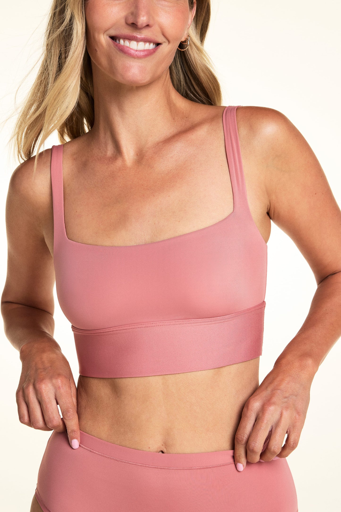 On a light neutral backdrop, Meagan wears the Bliss Squareneck Bralette in Cinnamon with matching underwear. The close-up highlights the square neckline, thin straps, longline band, and smooth microfiber fabric. sizing: Meagan wears size small