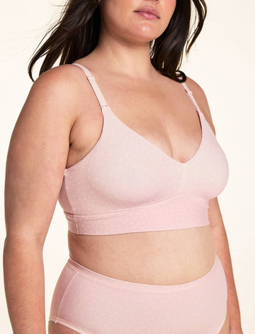 On a white studio backdrop, Alessandra wears the Bliss Triangle Bralette in Champagne Fizz, showing the V-neck triangle cups and adjustable shoulder straps, styled with a matching high-waist brief. sizing: Alessandra wears size Large