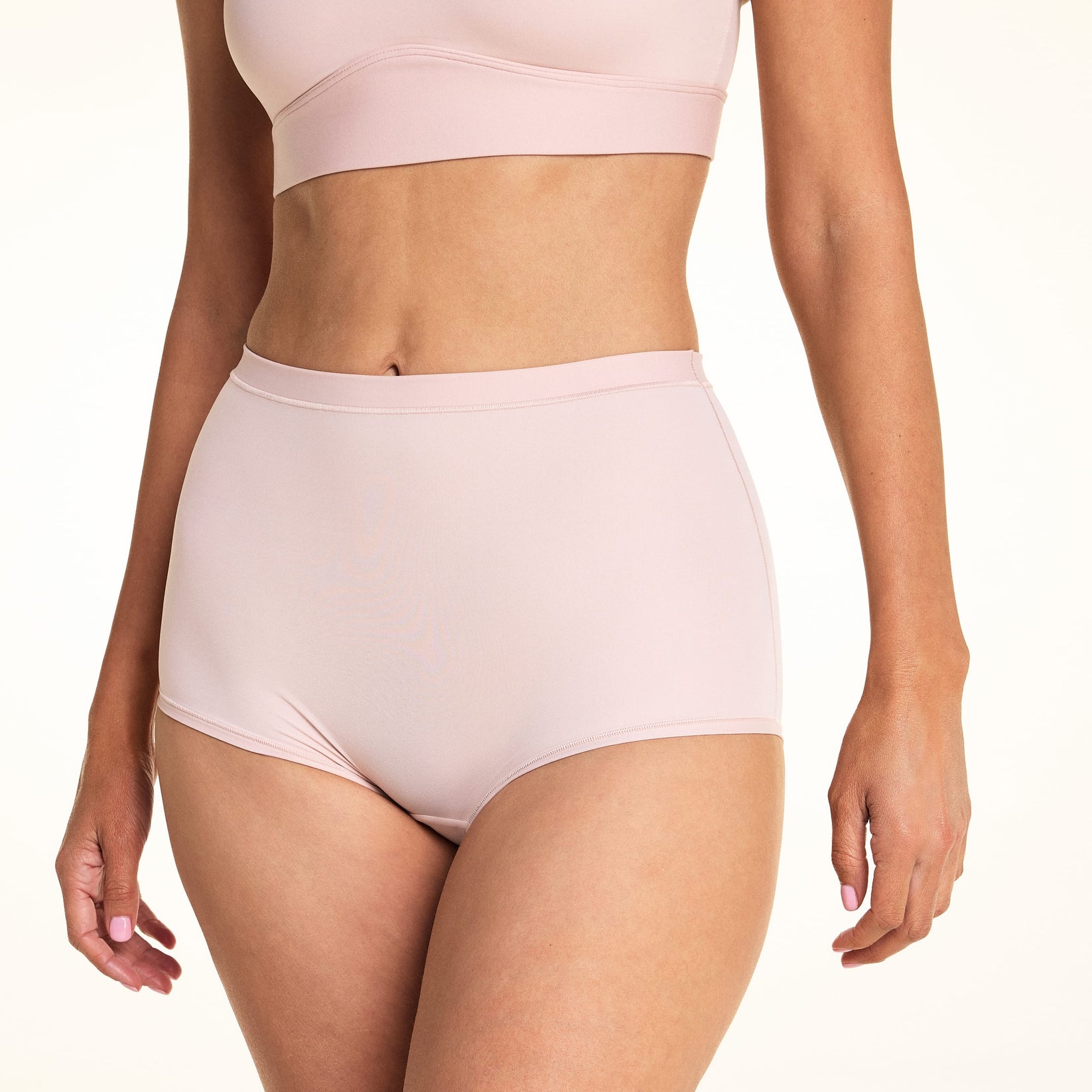 On a light studio backdrop, Meagan wears the Bliss Boyshort in Ember Rose. The cropped front view highlights the mid-rise waist, full-coverage silhouette, smooth fabric, and soft waistband.