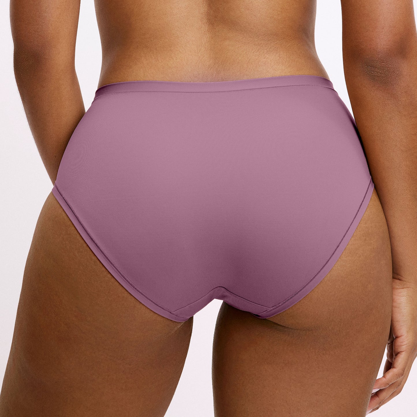 In a studio setting, Amber wears the Bliss High Waist underwear in Mirage, shown in a back close-up. The design features full coverage, a high-rise fit, and smooth, seamless fabric.