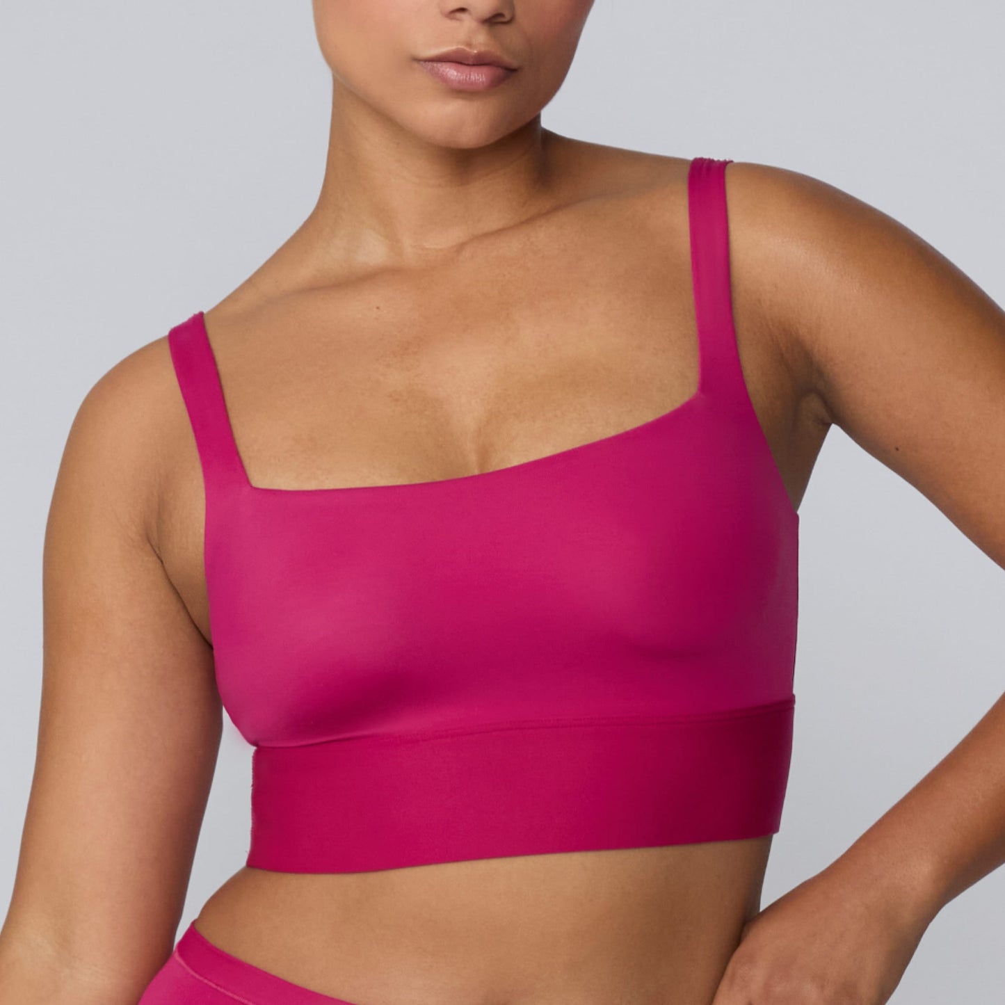 On a light gray studio backdrop, India wears the Bliss Square Neck Bralette in Winterberry. A close-up front view highlights the square neckline, wide straps, smooth fabric, and supportive underband.