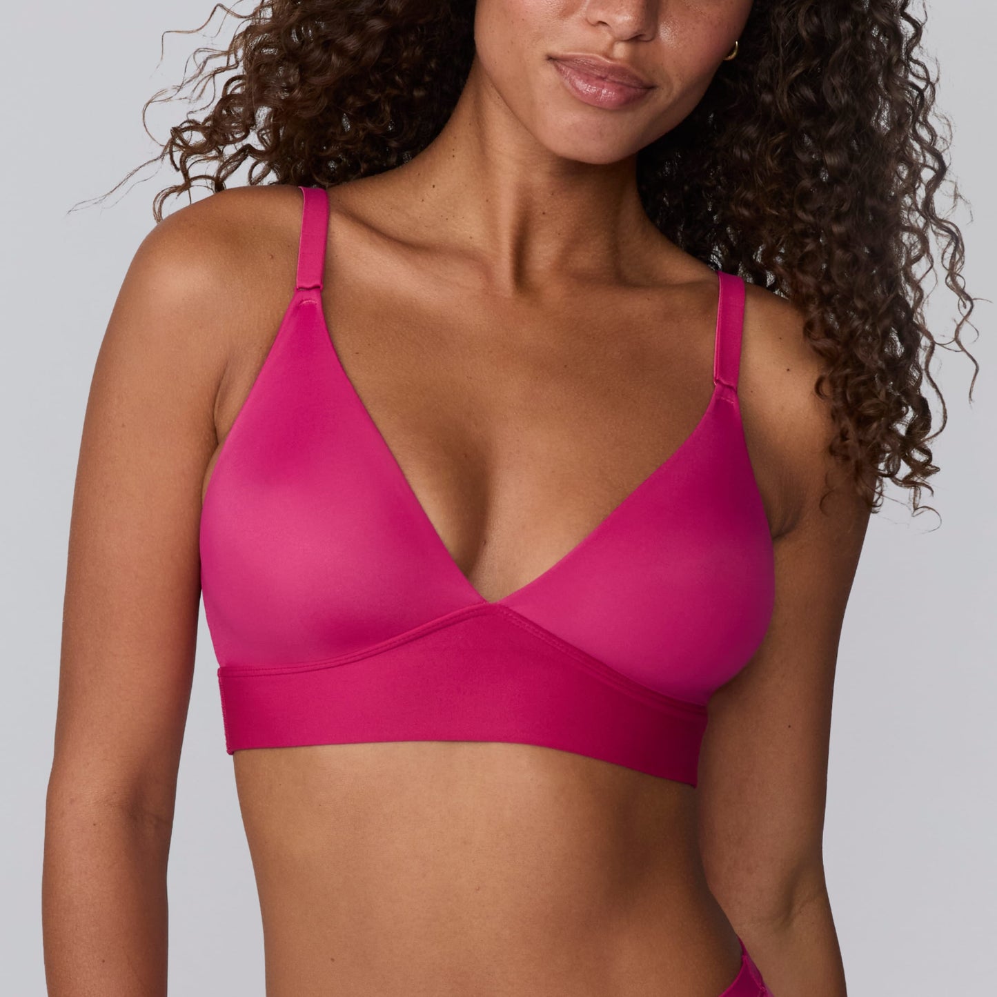 In a studio setting, Courtney wears the Bliss Triangle Bralette in Winterberry. A close-up front view highlights the deep V-neckline, smooth molded cups, adjustable straps, and wide underband for comfortable support.