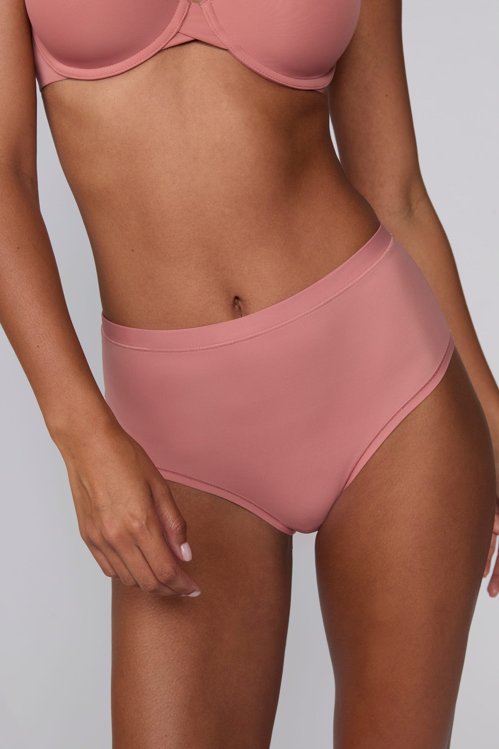 In a studio setting, Courtney wears the Bliss Highwaist Brief in Cinnamon. A close-up front view highlights the smooth fabric, high-rise waistband, and clean finish.