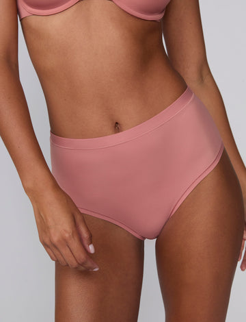 In a studio setting, Courtney wears the Bliss Highwaist Brief in Cinnamon. A close-up front view highlights the smooth fabric, high-rise waistband, and clean finish.