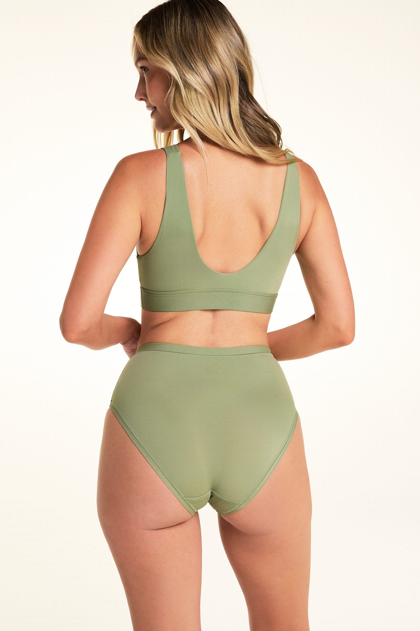 Back view of Meagan wearing the Bliss Highwaist Brief in Dill with the matching Bliss Bralette. The brief features a high-rise waist, full back coverage, and a smooth microfiber finish.