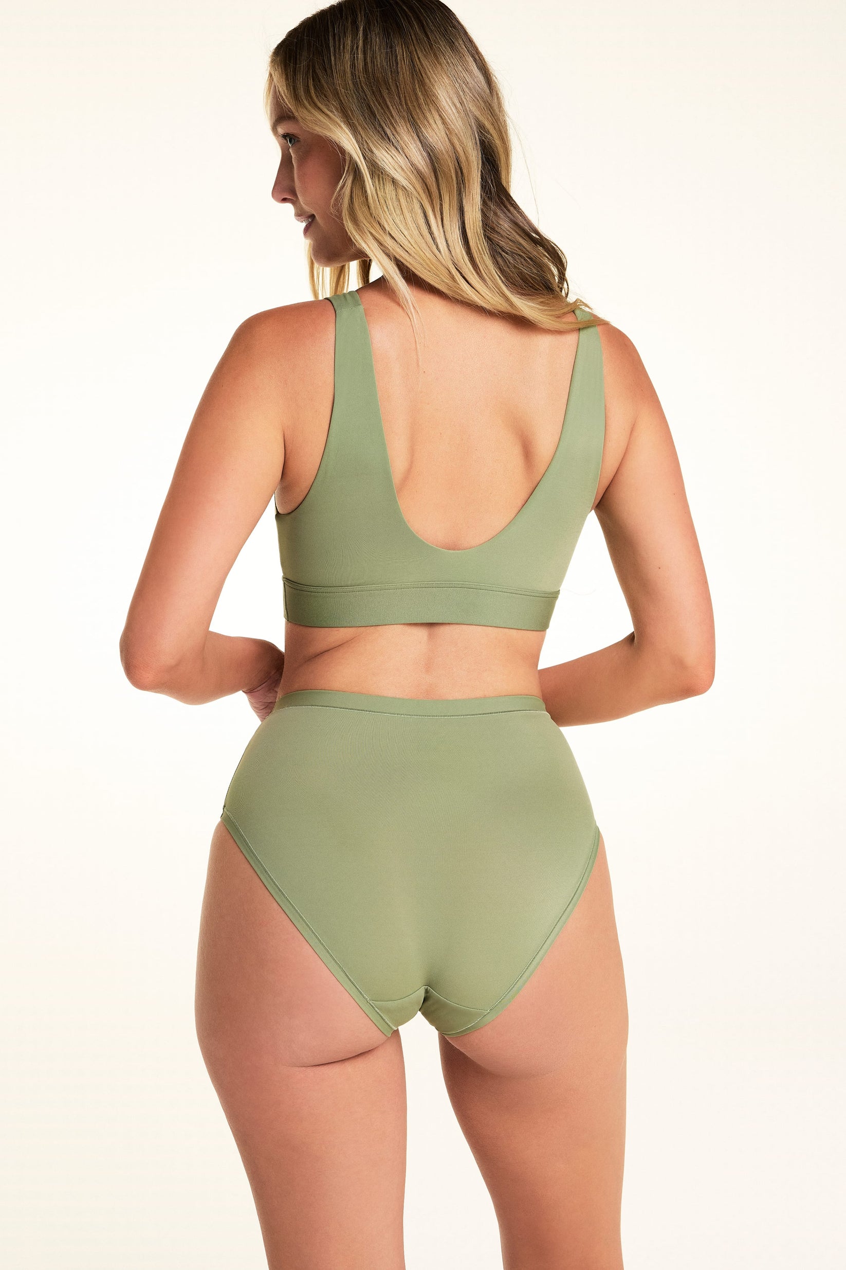 Back view of Meagan wearing the Bliss Highwaist Brief in Dill with the matching Bliss Bralette. The brief features a high-rise waist, full back coverage, and a smooth microfiber finish.
