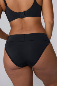 In a studio setting, India wears the Bliss Low Rise Bikini in Black. The back view highlights the smooth waistband and full back coverage.