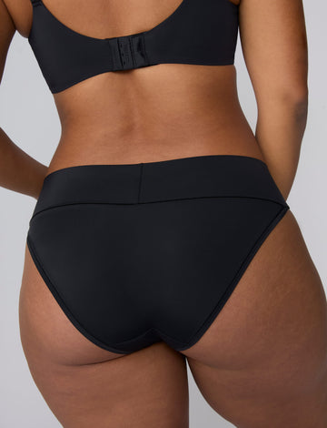 In a studio setting, India wears the Bliss Low Rise Bikini in Black. The back view highlights the smooth waistband and full back coverage.