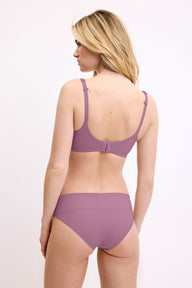 In a studio setting, a model wears the Bliss Low Rise Bikini in Mirage with a matching bra, shown from the back. The bikini features a low-rise fit, minimal coverage, and smooth, seamless fabric.