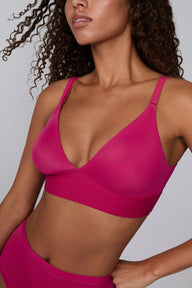 In a studio setting, Courtney wears the Bliss Triangle Bralette in Winterberry. A close-up view highlights the deep V-neckline, smooth molded cups, adjustable straps, and wide underband.
