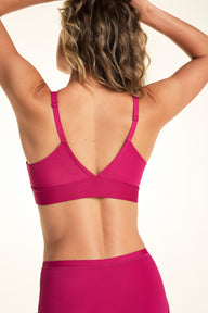 On a light studio backdrop, Alexis wears the Bliss Triangle Bralette in Winterberry. The back view showcases the V-back design, adjustable straps, and wide comfort band.