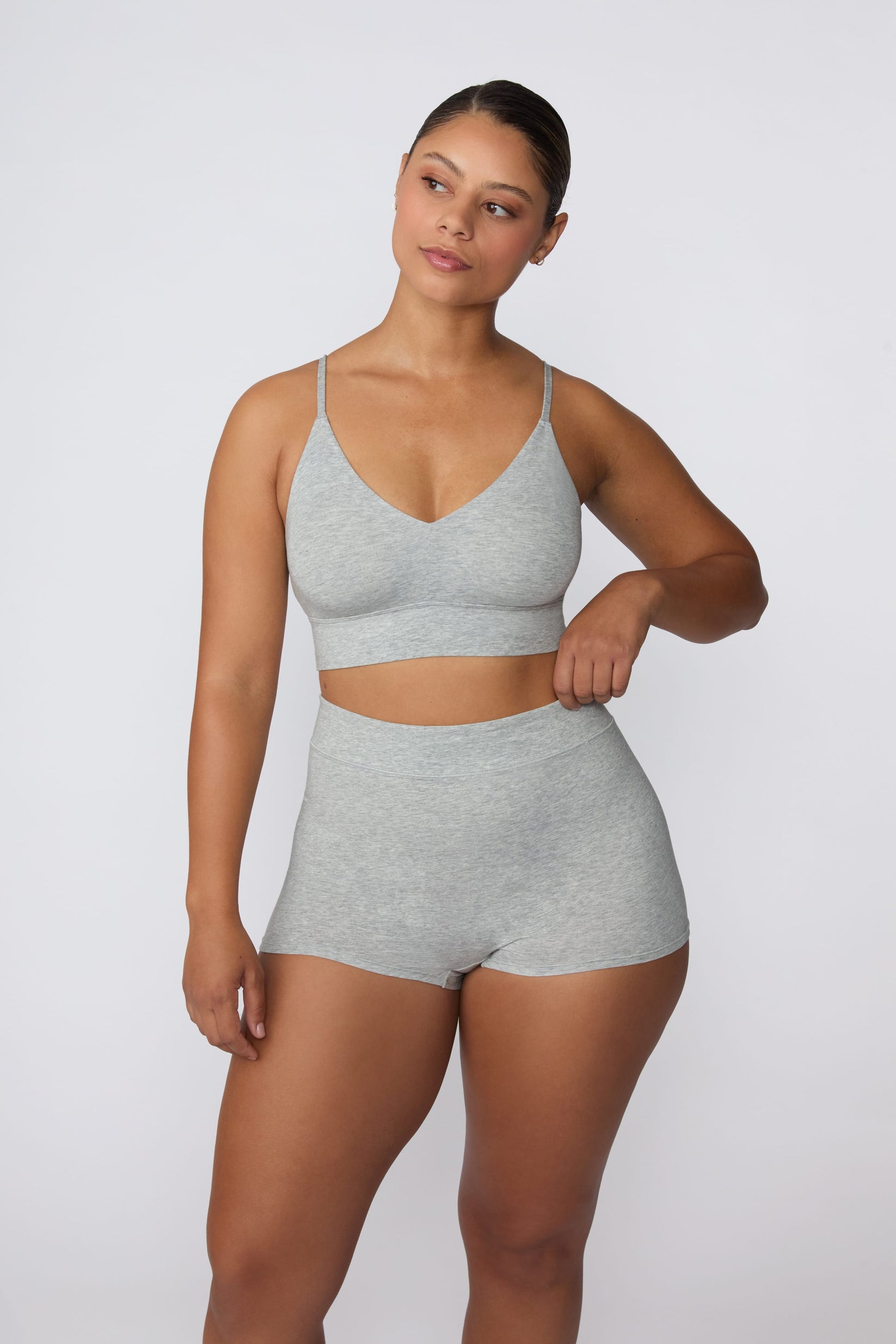 On a light gray studio backdrop, India wears the Cloud Cotton Boyshort in Heather Grey with the matching bralette. The full-body front view showcases the high-rise waistband, smooth fit, and longer leg coverage.