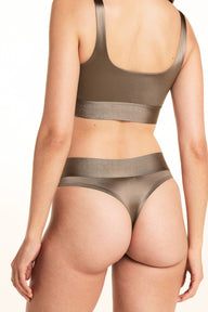On a studio backdrop, Laura is shown from the back wearing the Stretch Satin Square Neck Bralette and Stretch Satin Highwaist Thong in Sable, highlighting the bralette’s back band and the thong’s wide high-waisted waistband.