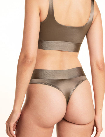 On a studio backdrop, Laura is shown from the back wearing the Stretch Satin Square Neck Bralette and Stretch Satin Highwaist Thong in Sable, highlighting the bralette’s back band and the thong’s wide high-waisted waistband.