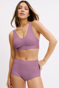 In a studio setting, Darion wears the Bliss Bralette in Mirage paired with matching underwear, shown in a front view. The bralette features a scoop neckline, wireless cups, and a smooth, wide underband for comfortable support. sizing: Darion wears size Small