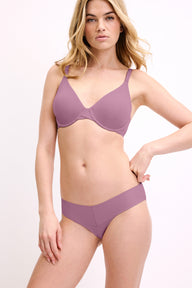 In a studio setting, a model wears the Bliss Low Rise Bikini in Mirage with a matching bra, shown in a front-facing pose. The design features a low-rise waistband, minimal coverage, and a smooth, seamless finish.