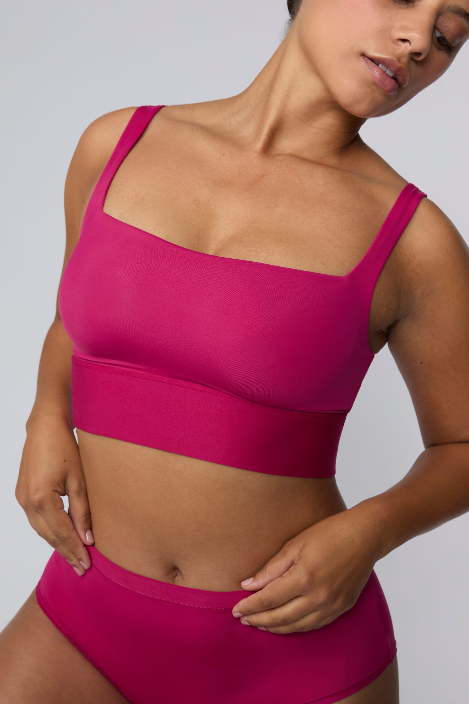 In a studio setting, India wears the Bliss Square Neck Bralette in Winterberry with matching underwear. A close-up view highlights the square neckline, smooth fabric, and wide underband.