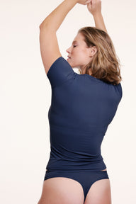 On a light studio backdrop, Sonnie wears the Bliss Tee in Navy, shown from the back with the matching underwear to highlight the smooth fit, short sleeves, and clean back silhouett