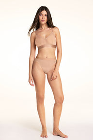 On a white studio backdrop, Laura wears the ComfortMesh Triangle Bralette and ComfortMesh High-Waist Brief in Taupe, shown in a full-length front view.