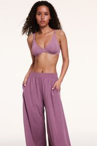 In a studio setting, Courtney wears the Base Unlined Bra in Mirage paired with matching lounge pants, shown in a full-body view. The bra features unlined underwire cups, a natural shape, and soft microfiber fabric for lightweight support.