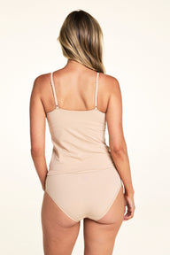 Against a white studio backdrop, Meagan stands with her back to the camera wearing the Bliss Cami in Beige with matching underwear, highlighting the adjustable straps and full back coverage.