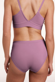 In a studio setting, Gianna wears the Bliss High Waist underwear in Mirage, shown from the back. The design features a high-rise silhouette, full coverage, and smooth, seamless fabric.