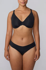 In a studio setting, India wears the Bliss Low Rise Bikini in Black with the matching bra in Black. The front view highlights the low-rise fit, smooth fabric, and clean waistband design.