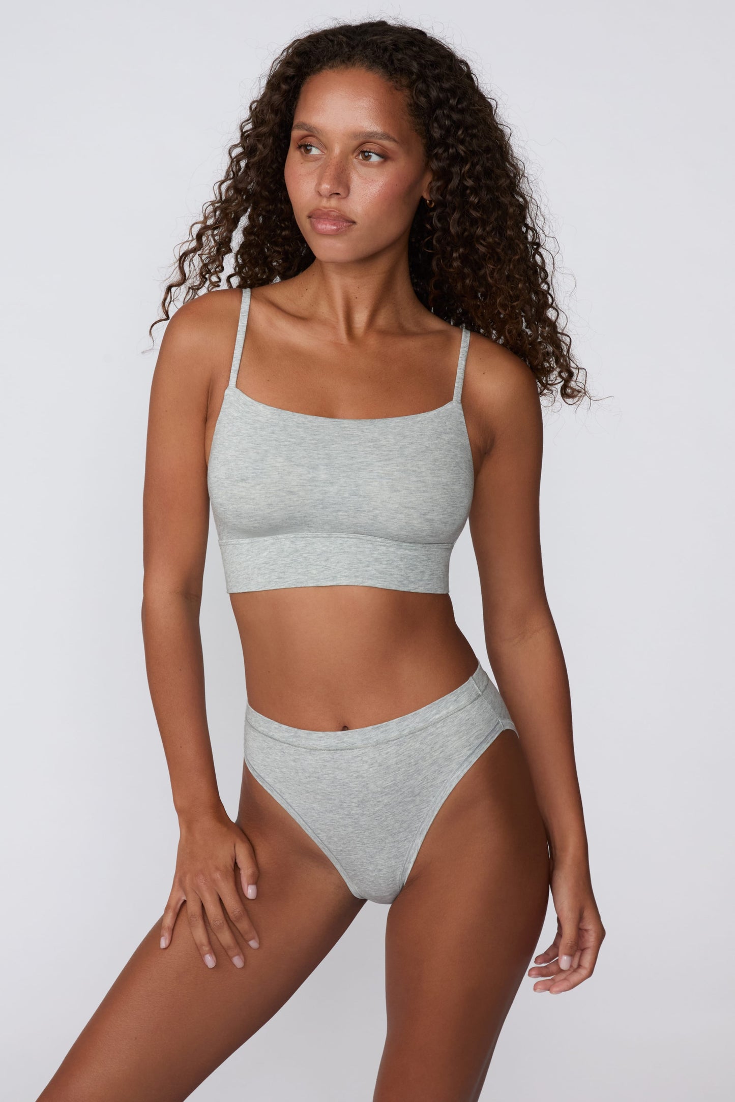 In a studio setting, Courtney wears the Cloud Cotton French Cut Brief in Heather Grey with the matching Cloud Cotton Thin Strap Bralette. The front view highlights the French-cut leg openings, mid-rise waistband, and soft cotton fabric.