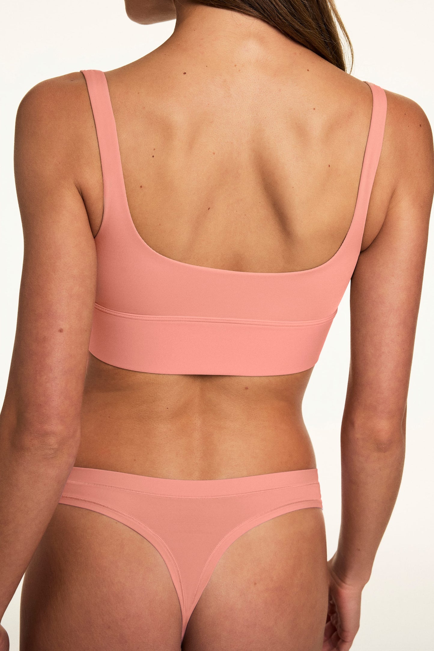 In a studio setting, Alana wears the Bliss Thong in Cabana with the matching Bliss bralette, showcasing the low-rise silhouette, smooth fabric, and minimal coverage fit.